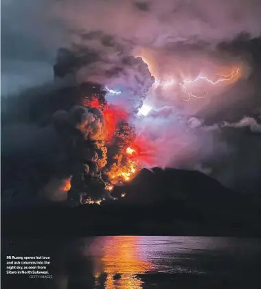  ?? GETTY IMAGES ?? Mt Ruang spews hot lava and ash columns into the night sky, as seen from Sitaro in North Sulawesi.