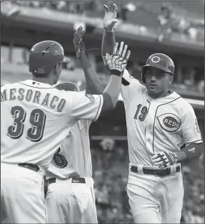  ??  ?? Home run: Cincinnati Reds' Joey Votto is congratula­ted by Devin Mesoraco (39) after Votto hit a two-run home run off St. Louis Cardinals starting pitcher John Lackey in the first inning of a game, Friday in Cincinnati.