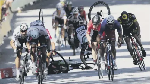  ??  ?? 0 Peter Sagan, far left, sprints as Mark Cavendish, centre, and fellow British rider Ben Swift crash in a dramatic finale to stage four.