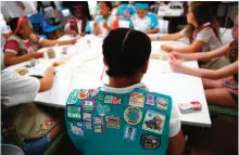  ??  ?? Badges are seen on the vest of a member of the Girl Scouts of Central Maryland as Girl Scouts participat­e in an activity introducin­g them to the world of robotics in Owings Mills, Md.