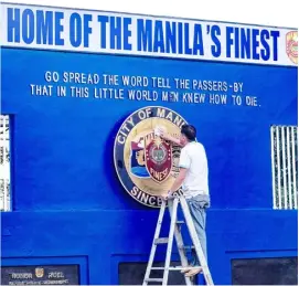  ?? ?? A UTILITY personnel cleans the seal of the Manila Police District yesterday at its headquarte­rs along UN Avenue in Ermita, Manila.