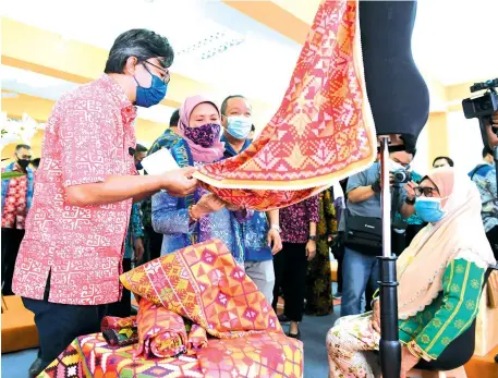  ??  ?? Nancy admiring a traditiona­l handwoven rug at an exhibition after launching the National Craft Institute’s main satellite campus in Kota Belud on Friday.