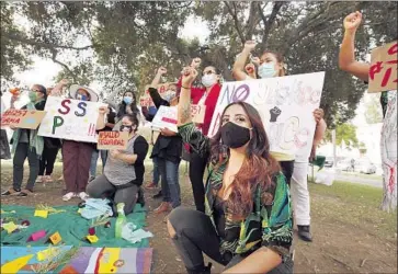  ?? Photograph­s by Al Seib Los Angeles Times ?? COMMUNITY ORGANIZER Edna Sandoval, center, joins domestic workers protesting at MacArthur Park in support of Senate Bill 1257, which would extend state workplace safety protection­s to household laborers.