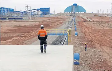  ?? REUTERS ?? An employee looks at the Oyu Tolgoi mine in Mongolia’s South Gobi region. The mine became a symbol of tense relations between Mongolia and foreign investors, with expansion plans delayed by disagreeme­nts.
