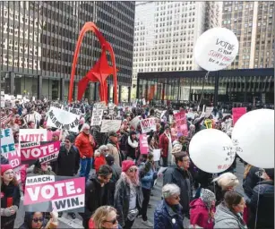  ??  ?? People hold signs during a rally in Chicago on Saturday to inspire voter turnout ahead of midterm polls in the United States.