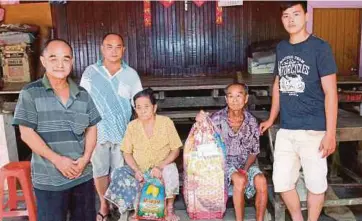  ??  ?? KEAT Oon (dua dari kiri) bersama ibu bapanya di Kampung Terumbu Lemal.