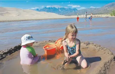  ?? Anne Herbst, Denver Post file ?? Children play in Medano Creek, which is at the base of the main dunefield at Great Sand Dunes National Park and Preserve. The creek usually flows from late April through mid-june, thanks to melting snow from the nearby Sangre de Cristo Mountains.