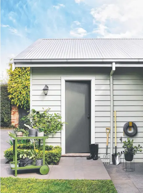  ??  ?? RIGHT: Dulux Gentle Calm Quarter (walls), Natural White (trim) and Jungle Cloak (door) refresh this shed while blending with its environmen­t.