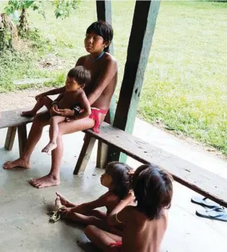  ??  ?? Carlo Zacquini con alcuni indigeni Yanomami alla missione della Consolata di Catrimani. A destra, dall’alto: Mariazinha all’interno della maloca della comunità Yanomami nel villaggio di Rokari; padre Corrado guada un sentiero nella foresta allagata