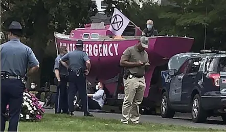  ?? Ap ?? YADA, YADA, REGATTA: State troopers stand near a pink sailboat with climate activists chained to it outside the home of Gov. Charlie Baker. The activists say Baker’s rubber-stamping approval of polluting energy projects.