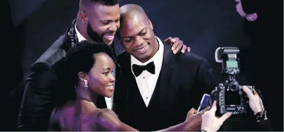 ?? MIKE COPPOLA/GETTY IMAGES ?? Lupita Nyong’o, left, Winston Duke and Marcus Henderson take a selfie during a break at the SAG Awards ceremony on Sunday night.
