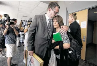  ?? PHOTOS BY DEBORAH CANNON / AMERICAN-STATESMAN ?? Eryn Baugh embraces wife Melissa outside of the courtroom on Friday. Cathy Lynn Henderson pleaded guilty to murder in the death of their son, 3-month-old Brandon Baugh.