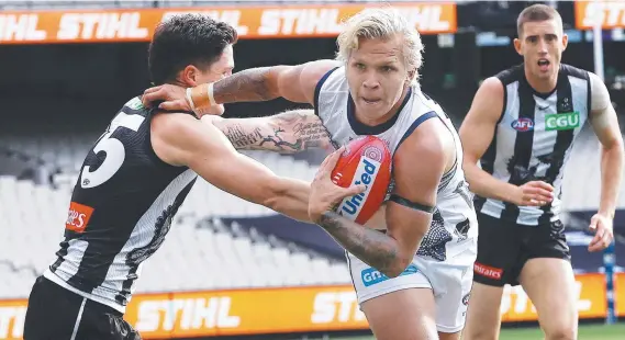  ??  ?? Quinton Narkle of the Cats tries to fend of Jack Crisp of the Magpies during their round 11 AFL match last month. Picture: Michael Klein