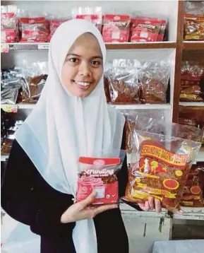  ?? [FOTO SYAHERAH MUSTAFA/BH] ?? Suziana menunjukka­n antara serunding yang dijual di kedainya di Jalan Kubur Maras, Kampung Langgar, Kota Bharu.