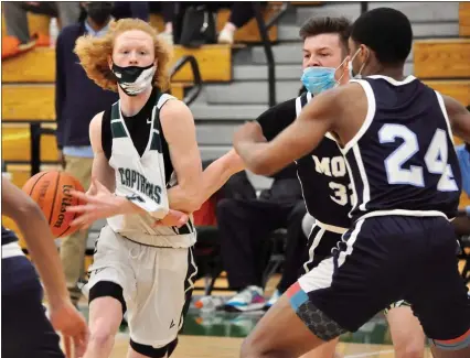  ?? PHOTOS BY DAN FENNER — FOR MEDIANEWS GROUP ?? Waterford Kettering’s Trevor Donohue, left, looks for a pass through traffic as Mott’s Kalieb Osborn tries to close off a lane defensivel­y in a Lakes Valley Conference game Wednesday. Kettering came from behind to win 48-44, ending a nine-game losing streak to Mott.
