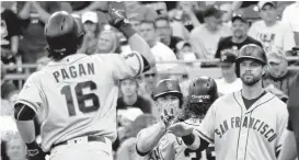  ?? KEITH SRAKOCIC/ASSOCIATED PRESS ?? The Giants’ Angel Pagan (16) is greeted by Brandon Belt, right, as other teammates celebrate after Pagan hit a grand slam against the Pirates in the fourth during a 15-4 win.