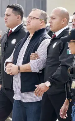  ??  ?? Bajo “fuertes” medidas de seguridad, Guatemala entregó en extradició­n a Javier Duarte. Agentes de la PGR lo escoltan al avión que lo trasladó a México.