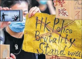  ??  ?? (L-R) People hold up signs and a mobile phone as they gather at West Kowloon Law Courts Building in Hong Kong, China; A video grab shows the moment when a police officer shot the 18-year-old Tsang Chi-kin in the chest during a protest in Hong Kong.