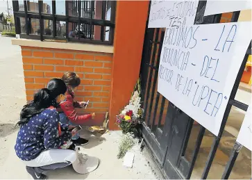  ?? EFE ?? Estudiante­s colocan velas hoy en las puertas de la UPEA en El Alto (Bolivia).