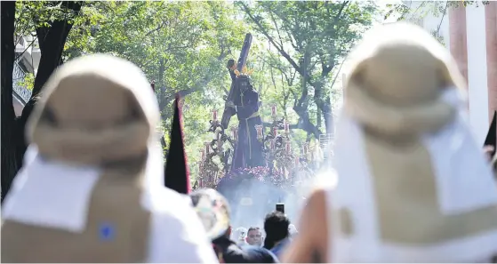  ?? JOAQUÍN CORCHERO/EP ?? Dos costaleros observan el discurrir de Nuestro Padre Jesús de la Humildad de la Hermandad de El Cerro.