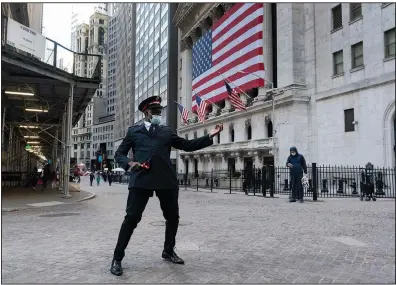  ?? (AP/Mark Lennihan) ?? Captain Chaka Watch with the Salvation Army plays air guitar in front of the New York Stock Exchange on Monday. The stock market rose on news that a second coronaviru­s vaccine shows promise.