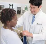  ??  ?? Dr. Ed Kimlin, medical director of
MedStar PromptCare urgent-care
centers, fits a patient with an arm sling.