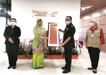  ??  ?? Fatimah (second left) receives a memento from Mohamad Rosidek. Also in the picture are Caroline (left) and Dr Ong.