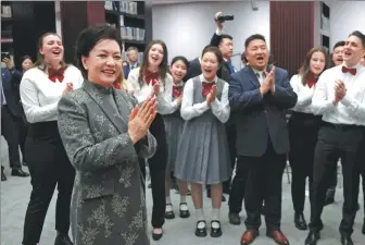  ?? WANG JING / CHINA DAILY ?? Peng Liyuan, wife of President Xi Jinping, interacts with the visiting members of Burg Chinese Chorus from Essen, Germany, on Thursday at Beijing No 35 High School.