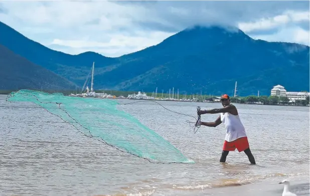  ?? Picture: JUSTIN BRIERTY ?? GOOD CATCH: Joel Anau, from Townsville, tries his luck with cast netting at high tide along the Cairns Esplanade.