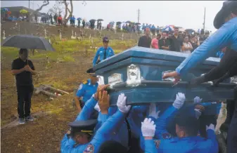  ?? Ramon Espinosa / Associated Press 2017 ?? Police lift the coffin of officer Luis Angel Gonzalez, who died trying to drive across a river in Aguada during Hurricane Maria. A new report says the storm caused more than 4,600 deaths.