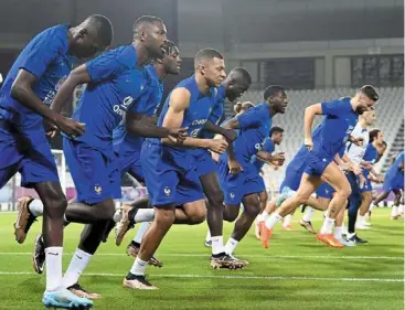  ?? — AFP ?? Focused: France’s Kylian mbappe (centre) and olivier Giroud (right) training with teammates in doha.