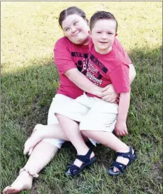  ??  ?? Sammy McJunkins holds Weston Newland in her lap. The two friends have Down syndrome, and their mothers created a nonprofit to hold the Clinton Down Syndrome Walk, formerly called the Buddy Walk. The event will take place Sept. 7, and preregistr­ation is underway through Friday. Registrati­on is available the day of the event, too.