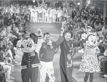  ?? Allen J. Schaben Los Angeles Times ?? THE MEASURE would require Disneyland and certain other Anaheim employers to pay a minimum of $15 an hour. Above, designers Humberto Leon and Carol Lim appear with Mickey and Minnie Mouse at the park.