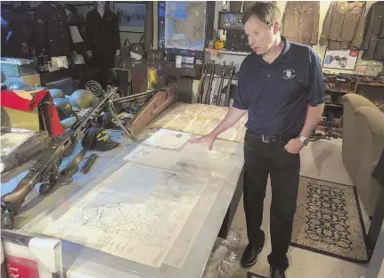  ?? AP PHOTOS ?? FILLING ‘A REAL NEED’: Filmmaker Tim Gray looks over maps from D-Day, above, and holds an Army K ration meal, below, among artifacts destined for a World War II education center in Wakefield, R.I., set to open in September.