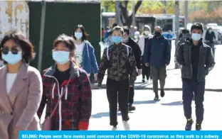  ??  ?? BEIJING: People wear face masks amid concerns of the COVID-19 coronaviru­s as they walk to a subway station in Beijing. — AFP
