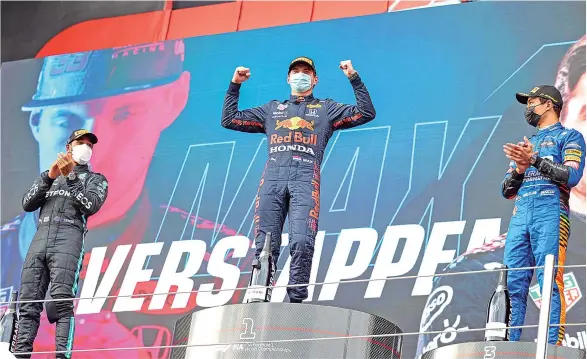  ?? FOTO: AFP ?? Max Verstappen celebra su victoria, junto a Lewis Hamilton (izq.) y Lando Norris (der.), en el podio. /