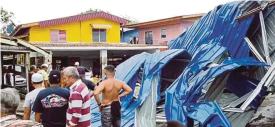  ?? [ FOTO ABDUL RAHEMANG TAIMING/BH ] ?? Penduduk mengalihka­n atap rumah dalam kejadian ribut di Kampung Maspul malam tadi.