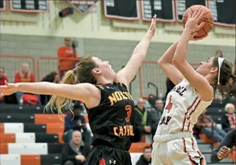  ??  ?? Maria Cerro, right, of Class 6A fourth-ranked Bethel Park, gets a shot up against 4A topranked North Catholic’s Cassie Foster Monday night. The Blackhawks won, 59-52.