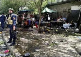  ?? ALI ABDUL HASSAN — THE ASSOCIATED PRESS ?? Security forces and civilians gather Sunday at the scene of a bombing in Baghdad, Iraq.