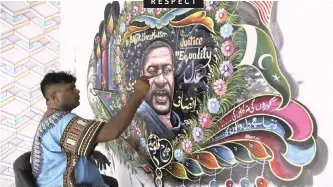  ?? | AP ?? PAKISTANI artist Haider Ali paints a portrait of George Floyd on the wall of his home in Karachi, Pakistan, yesterday. Ali painted the mural to pay tribute to the black man who died after being restrained by police officers in Minneapoli­s.