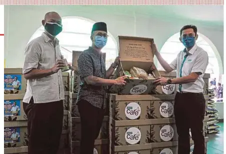  ?? BERNAMA PIC ?? Finance Minister Tengku Datuk Seri Zafrul Tengku Abdul Aziz (centre) showing food baskets donated by Bank Simpanan Nasional to needy families at Masjid Al-Hasanah, Bangi, yesterday. With him are Bank Simpanan Nasional chief executive officer Jay Khairil Jeremy Abdullah (right) and Bangi member of parliament Dr Ong Kian Ming.