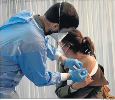  ?? JUAN CARLOS MUÑOZ ?? Un enfermero administra una dosis de Astrazenec­a a una mujer en un centro de vacunación de Sevilla.