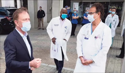  ?? Mark Lennihan / Associated Press file photo ?? Gov. Ned Lamont, left, talked with medical staff outside Saint Francis Hospital in a May 2020.