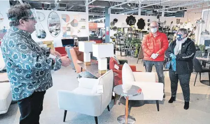  ?? PAUL CHIASSON THE CANADIAN PRESS ?? A sales clerk keeps his distance from clients at a furniture store in St-Jean-sur-Richelieu, Que., on Monday.