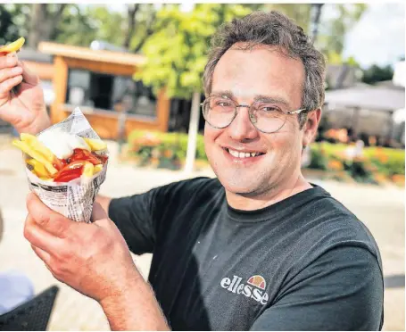  ?? FOTO: RALPH MATZERATH ?? Pascal Lütz verkauft im Büdchen am Altstadtbi­ergarten Pommes in der Tüte.
nd