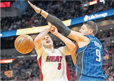  ?? CHARLES TRAINOR JR./TNS ?? Miami Heat’s Tyler Johnson is blocked under the basket by the Orlando Magic’s Nikola Vucevic in the second quarter Monday.