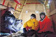  ?? COLIN CHISHOLM ?? From left, Jennifer Dill, Donna Eldridge, and Kathy Riley try to stay warm inside a makeshift tent. They spend the night inside it each year to bring attention and awareness of the plight of homeless and displaced people.