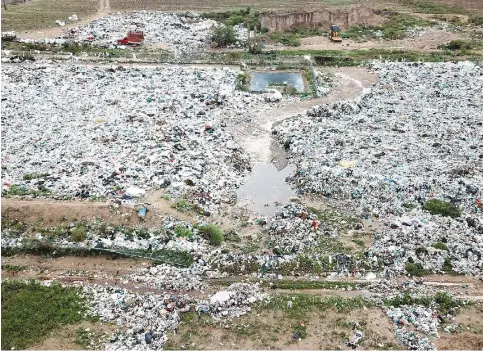  ??  ?? Destrozos. Más de 25 toneladas de basura fueron esparcidas por la corriente de agua; con maquinaria pesada rentada realizan maniobras para colocar los desechos en su lugar.