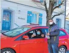  ?? FOTO: GAUGGEL ?? Timo Mordan, Vizepräsid­ent der Benzinger Germanenzu­nft, übergibt einen „Fasnetsgru­ß in der Tüte“bei der Drive-in-Aktion am Fasnetssam­stag.