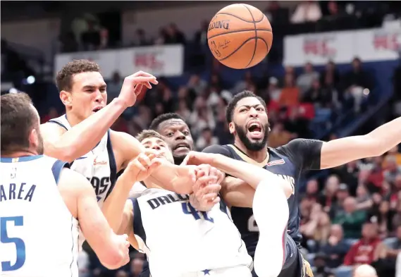  ?? AP FOTO ?? BATTLE. Anthony Davis (right) battles for possession against three Dallas Mavericks players in a close win by the New Orleans Pelicans.